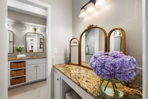 a spacious bathroom with a granite countertop sink and a mirror