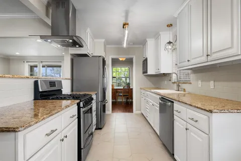 a kitchen with stainless steel appliances granite countertop a sink stove and refrigerator