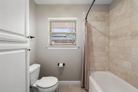 a white toilet sitting next to a bath tub
