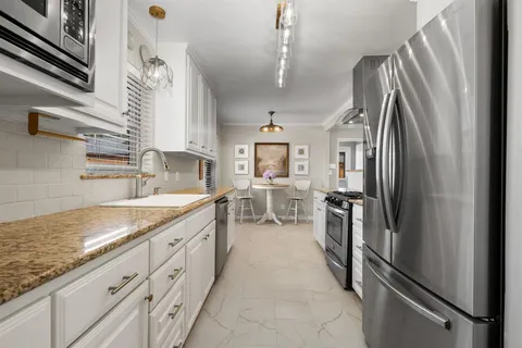 a kitchen with stainless steel appliances granite countertop a refrigerator and a sink