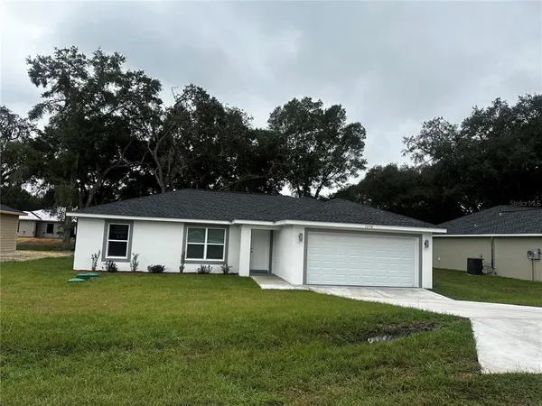 a front view of house with a garden and deck