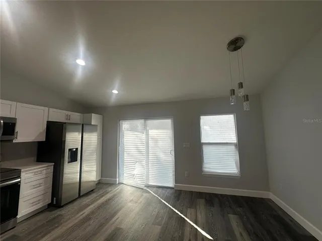 an empty room with wooden floor and a window