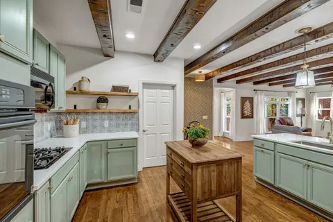 a kitchen with stainless steel appliances granite countertop a refrigerator and a stove top oven