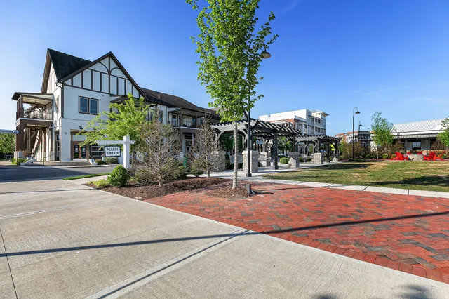 a front view of a house with a garden and trees