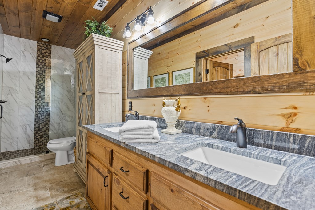 245 East Shalom Court Blue Ridge, GA 30513 - Photo 68 of 78 a bathroom with a granite countertop double vanity sink and a mirror