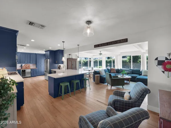 a kitchen with stainless steel appliances granite countertop a sink dishwasher stove refrigerator and cabinets with wooden floor