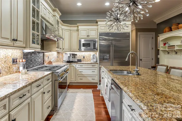a kitchen with stainless steel appliances granite countertop a stove and a sink