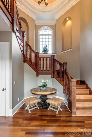 a view of a hallway with wooden floor and staircase