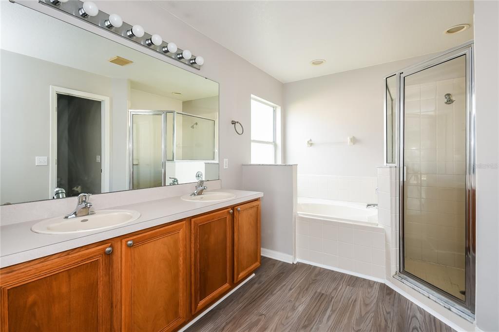 1170 Creekview Court St. Cloud, FL 34772 - Photo 11 of 17 a bathroom with a double vanity sink a mirror and a bathtub