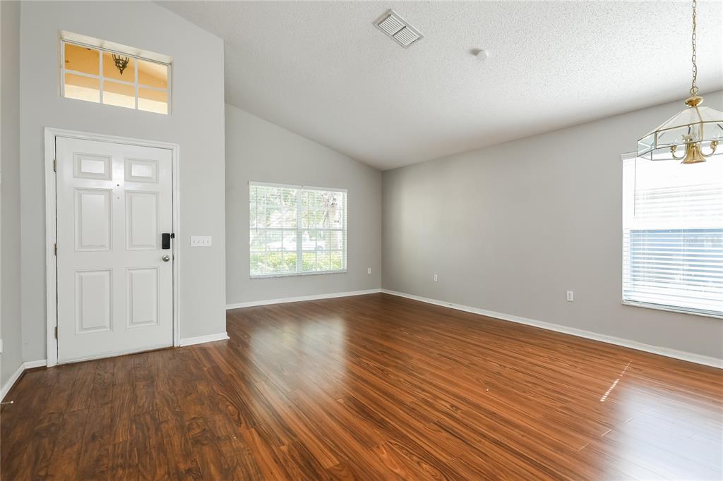 1170 Creekview Court St. Cloud, FL 34772 - Photo 3 of 17 an empty room with wooden floor and windows