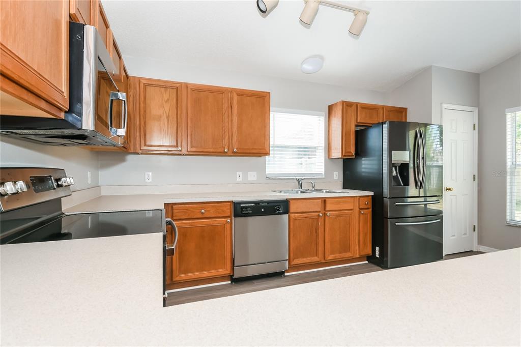 1170 Creekview Court St. Cloud, FL 34772 - Photo 6 of 17 a kitchen with stainless steel appliances granite countertop a refrigerator and a sink