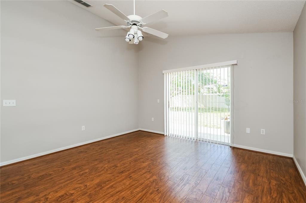 1170 Creekview Court St. Cloud, FL 34772 - Photo 9 of 17 an empty room with wooden floor fan and windows