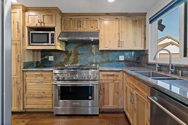 a kitchen with stainless steel appliances granite countertop a stove and a sink