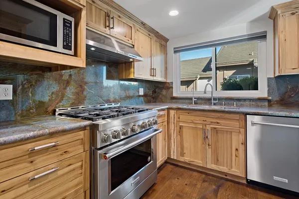 a kitchen with stainless steel appliances granite countertop a stove and a sink