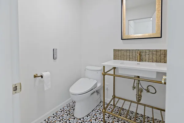 a bathroom with a toilet a sink and mirror