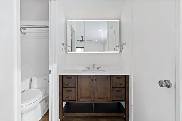 a white toilet next to a bathroom