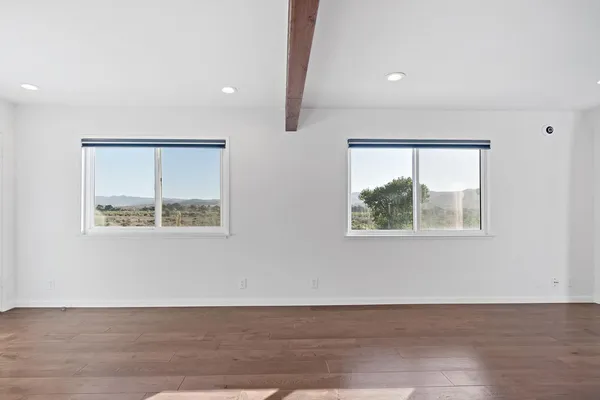 an empty room with wooden floor and a window