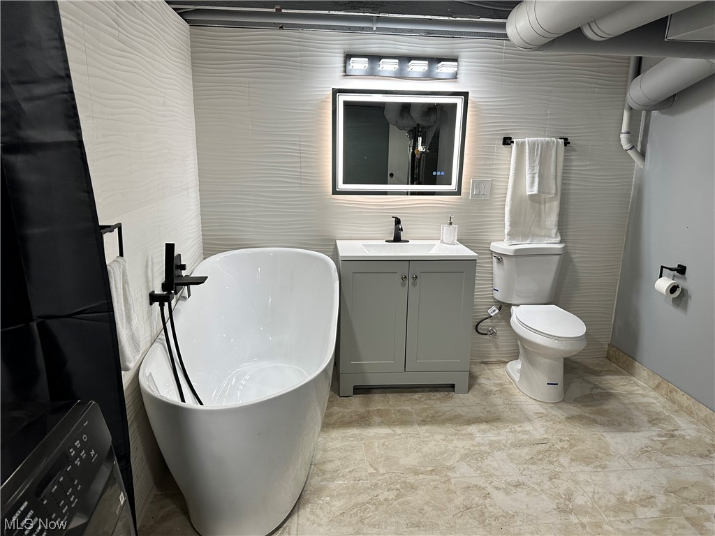 326 Babbitt Road Euclid, OH 44123 - Photo 22 of 26 Bathroom with tile floors, toilet, vanity, and a bathing tub