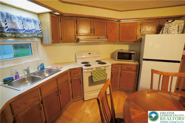 a view of a kitchen with sink and refrigerator