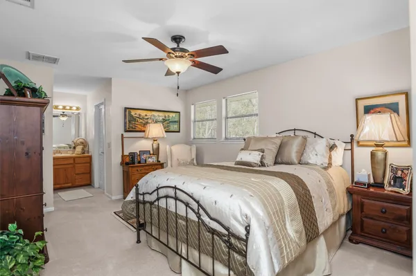 a bedroom with a bed a chandelier and dresser