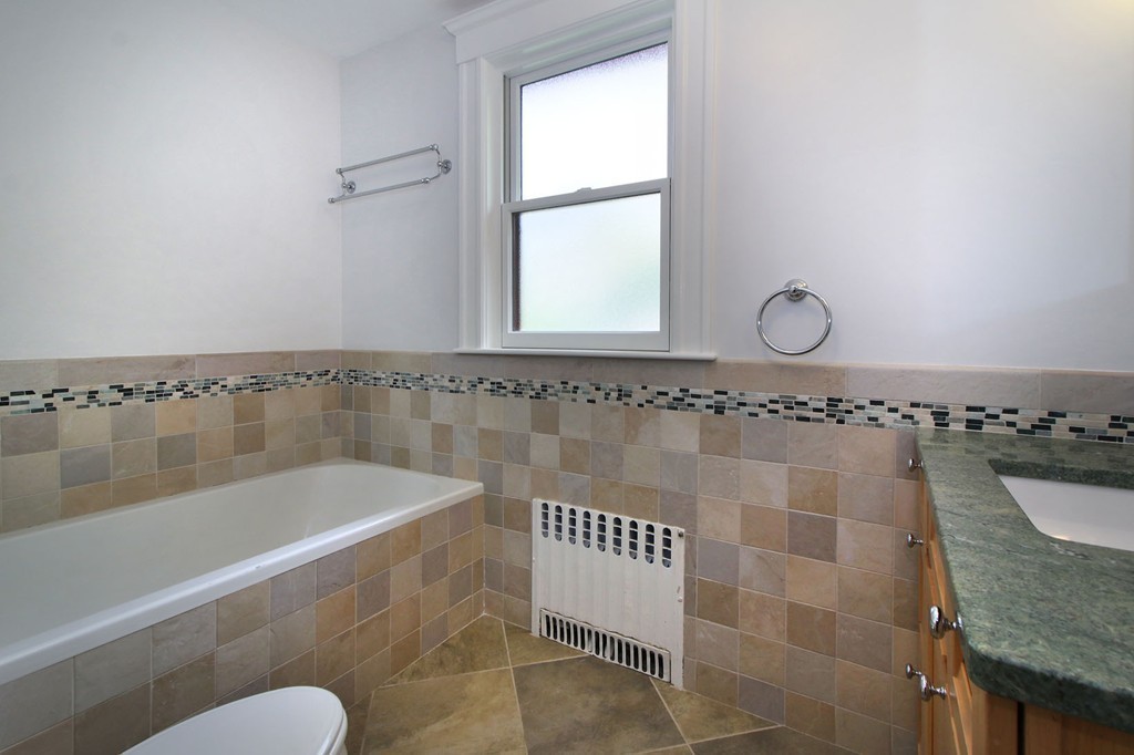 57 Winthrop Road, Unit 1 Brookline, MA 02445 - Photo 12 of 17 a bath tub sitting next to a blue bathroom sink