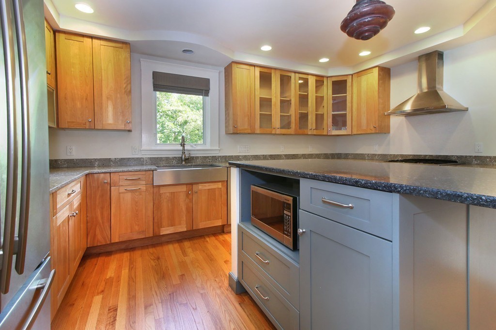 57 Winthrop Road, Unit 1 Brookline, MA 02445 - Photo 5 of 17 a kitchen with kitchen island granite countertop wooden floors and white cabinets