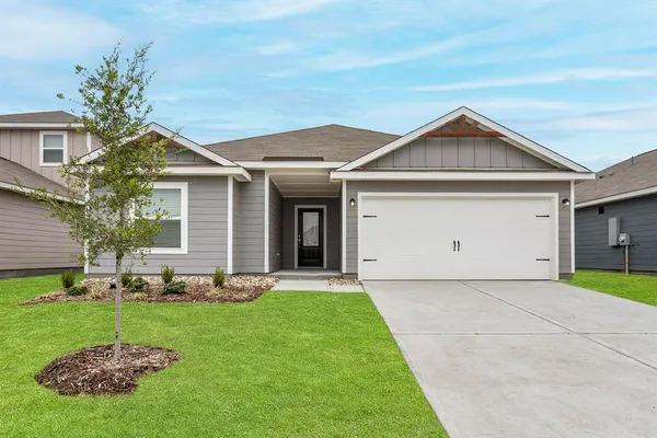 a front view of a house with a garden and plants