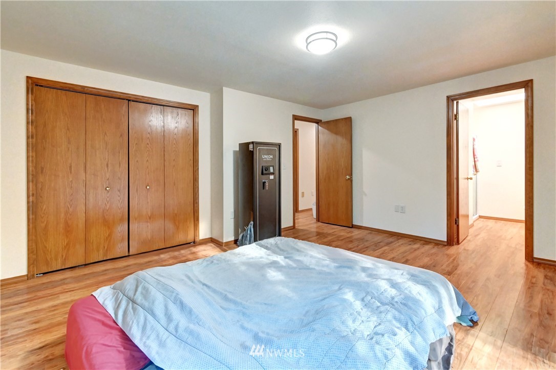 15220 OK Mill Road Snohomish, WA 98290 - Photo 8 of 26 a bedroom with a large bed and wooden floor