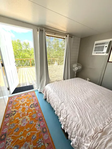a bedroom with a bed and a large window