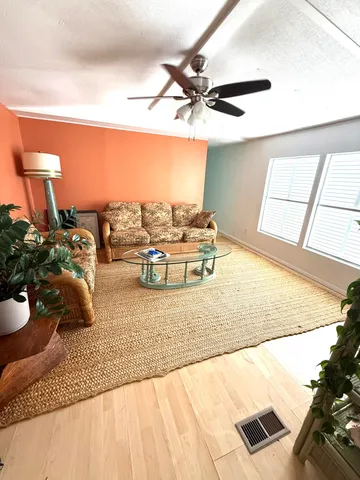 a kitchen with stainless steel appliances kitchen island granite countertop a sink dishwasher and white cabinets with wooden floor