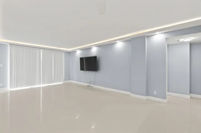 a view of a hallway with a cabinet and chandelier fan