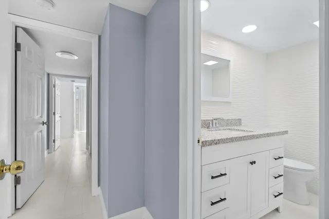 a bathroom with a granite countertop sink a toilet and a mirror