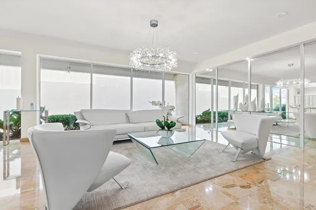 a living room with couches potted plants and a large window with garden view