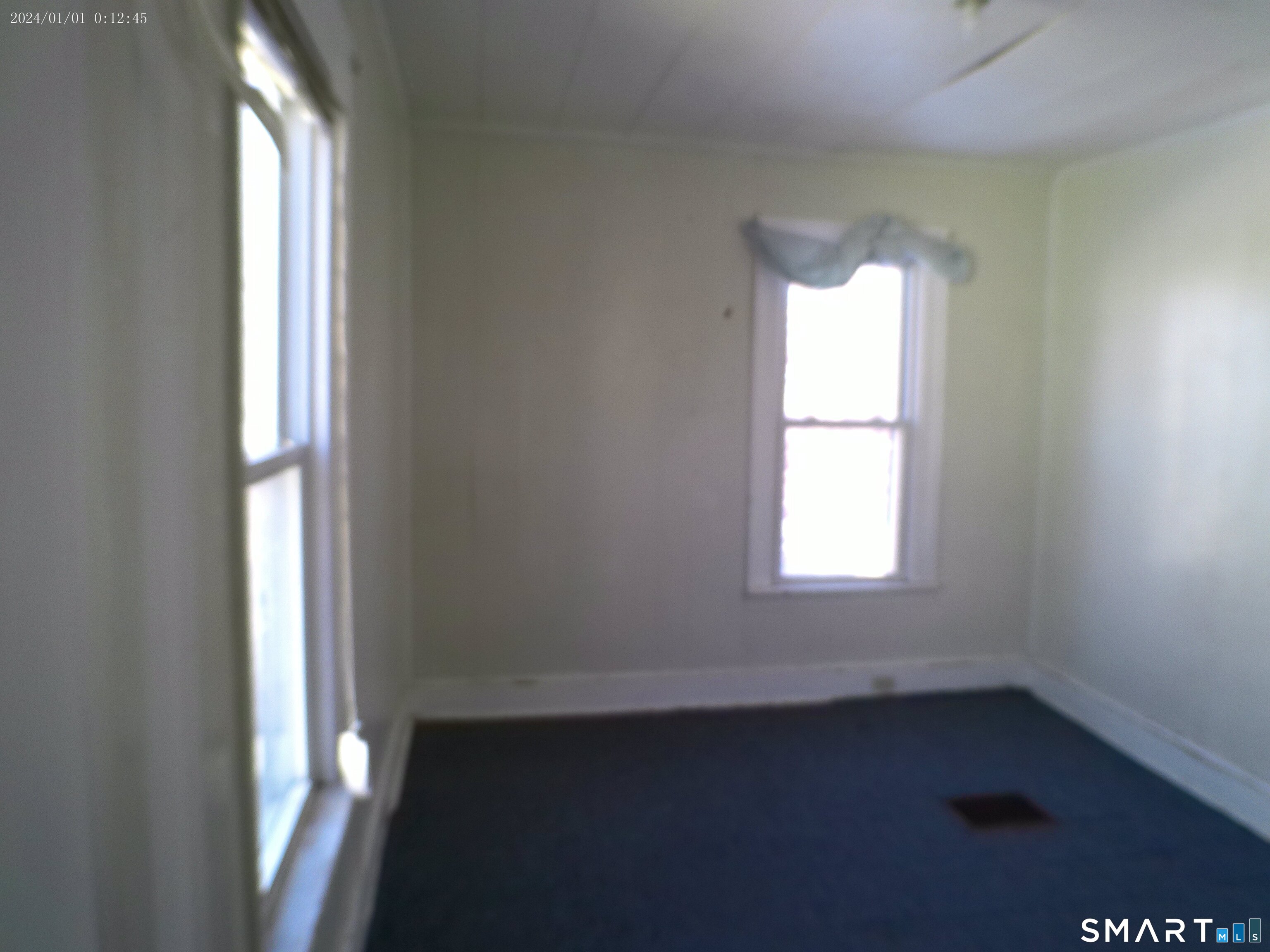 306 Carroll Avenue Bridgeport, CT 06607 - Photo 4 of 15 an empty room with wooden floor and windows