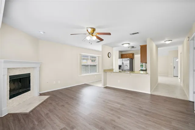 a view of an empty room with a fireplace and a window