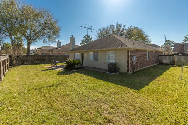a view of a house with backyard and sitting area
