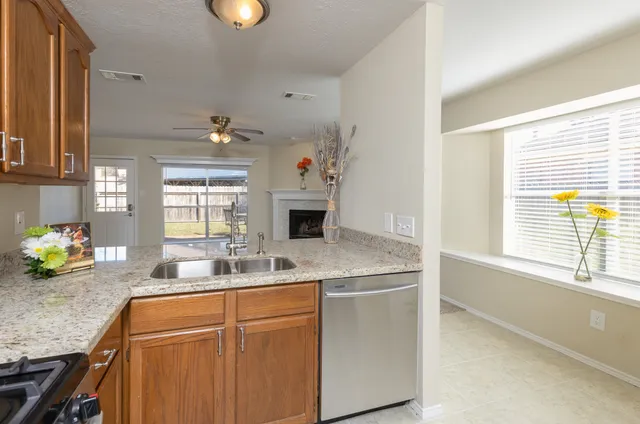 a kitchen with granite countertop a sink cabinets and window