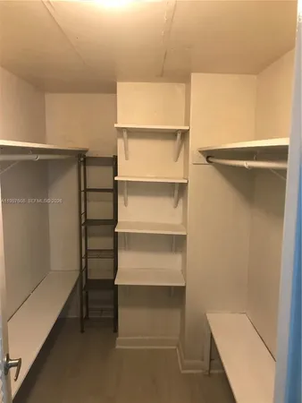 a view of walk in closet with empty racks