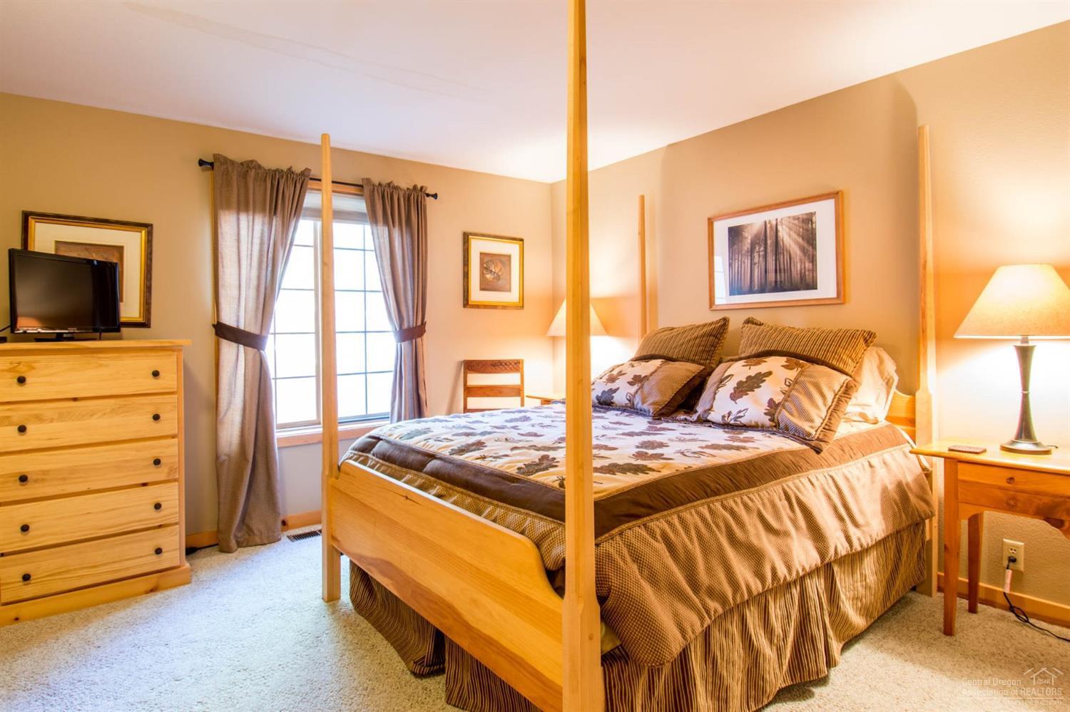 57522 Circle 4 Cabin Road Sunriver, OR 97707 - Photo 10 of 25 a bedroom with a bed and a flat tv screen on dresser