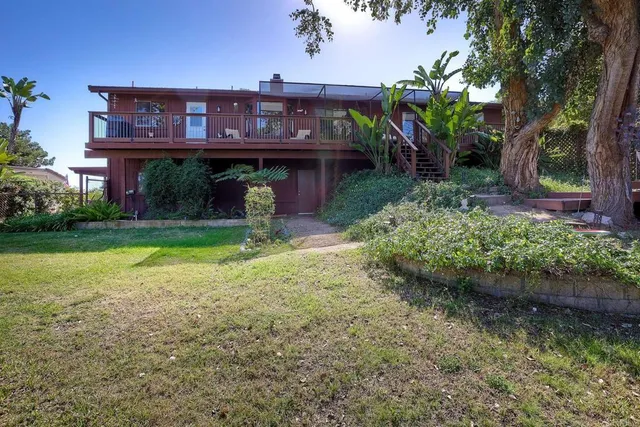 a view of a house with a yard and a tree
