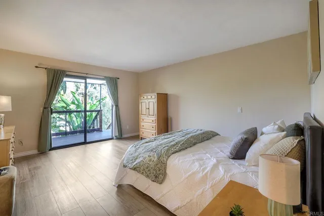 a bedroom with a bed painting on wall and a window