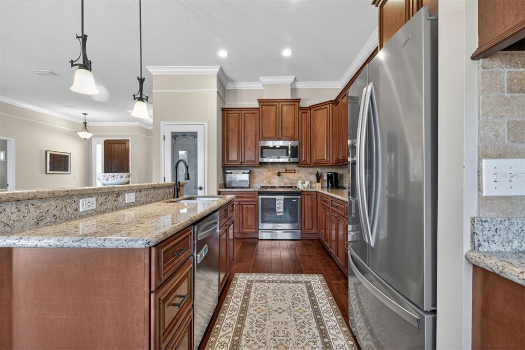 11949 Northwest 13 Road Gainesville, FL 32606 - Photo 2 of 46 a kitchen with kitchen island granite countertop a sink a counter top space stainless steel appliances and cabinets