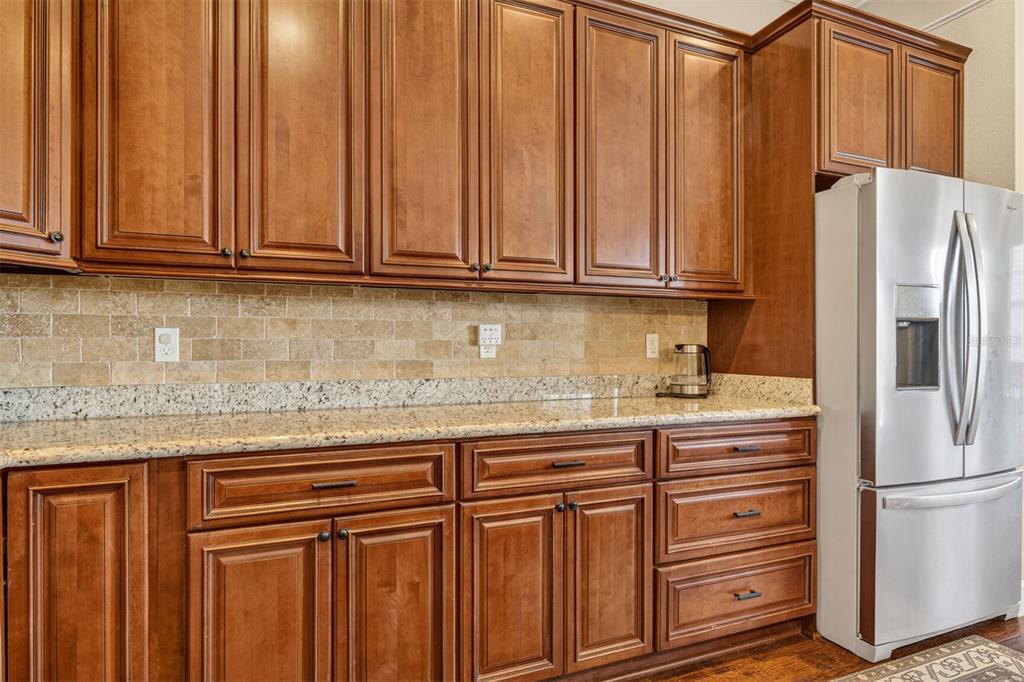 11949 Northwest 13 Road Gainesville, FL 32606 - Photo 24 of 46 a kitchen with granite countertop a refrigerator and cabinets