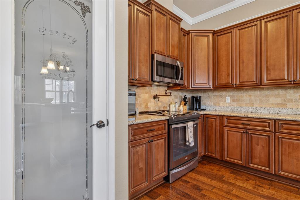 11949 Northwest 13 Road Gainesville, FL 32606 - Photo 3 of 46 a kitchen with stainless steel appliances granite countertop a stove top oven a sink and dishwasher with wooden floor