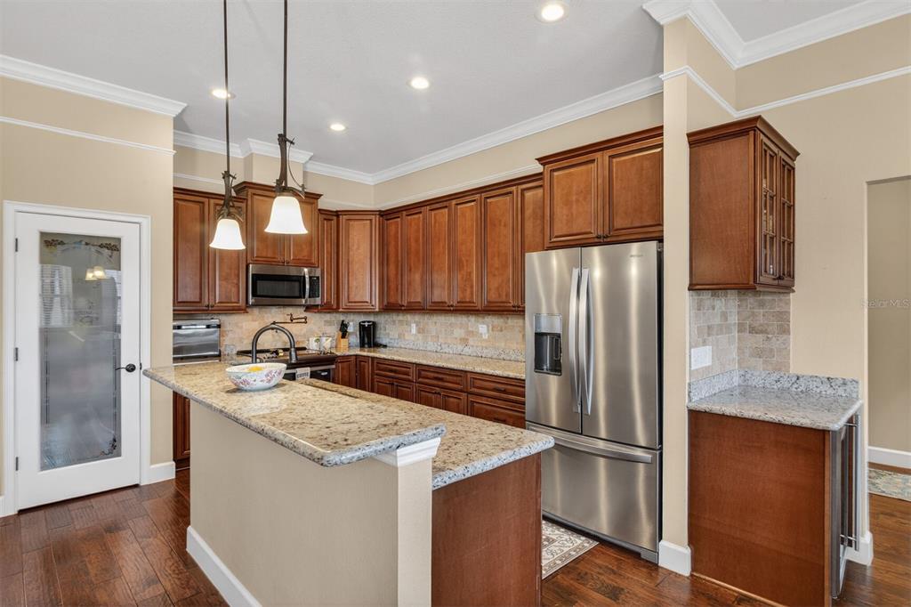 11949 Northwest 13 Road Gainesville, FL 32606 - Photo 7 of 46 a kitchen with a refrigerator a sink and wooden cabinets
