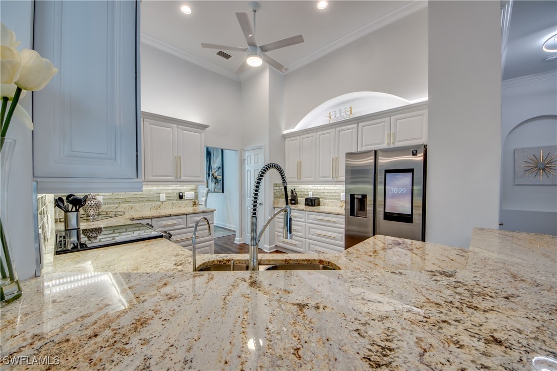 2703 Southwest 43rd Terrace Cape Coral, FL 33914 - Photo 12 of 50 a view of a kitchen with stainless steel appliances kitchen island granite countertop a refrigerator a stove and a sink with granite countertops