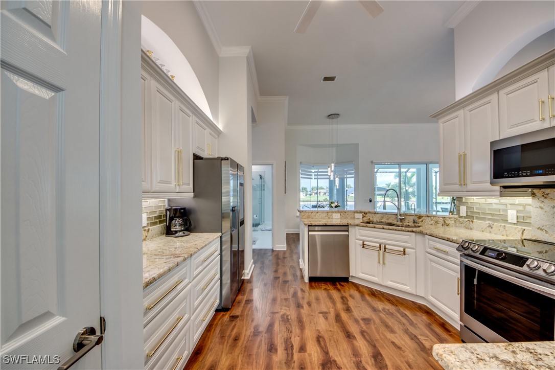 2703 Southwest 43rd Terrace Cape Coral, FL 33914 - Photo 17 of 50 a kitchen with a sink stove microwave and refrigerator