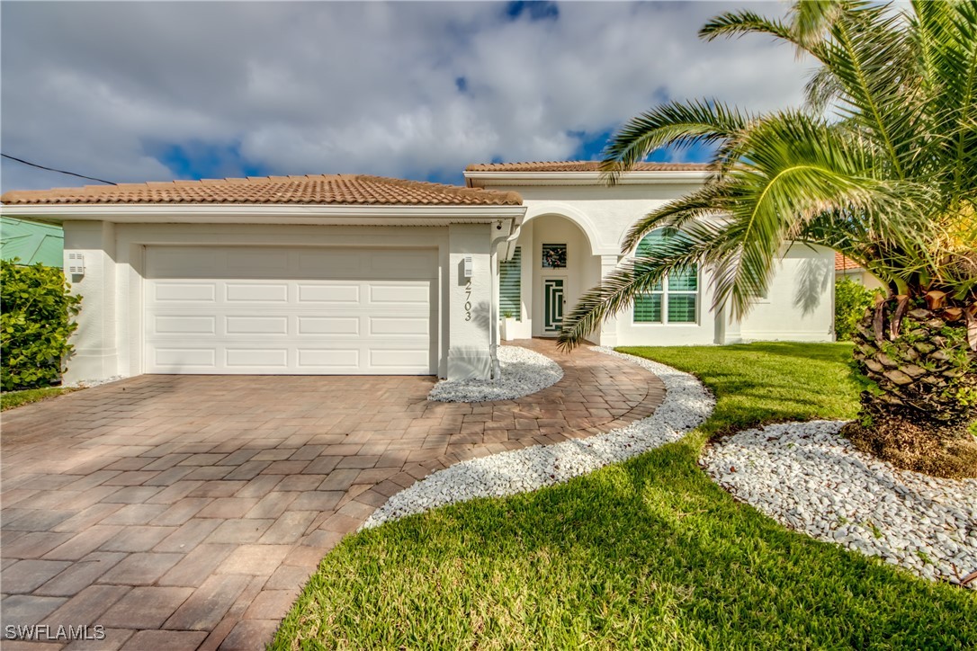 2703 Southwest 43rd Terrace Cape Coral, FL 33914 - Photo 2 of 50 a view of a house with a yard and garage