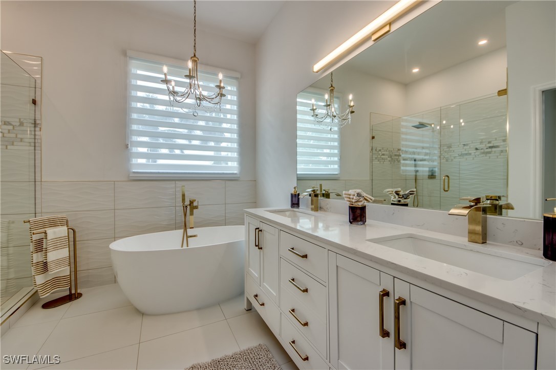 2703 Southwest 43rd Terrace Cape Coral, FL 33914 - Photo 22 of 50 a bathroom with a double vanity sink bathtub and shower