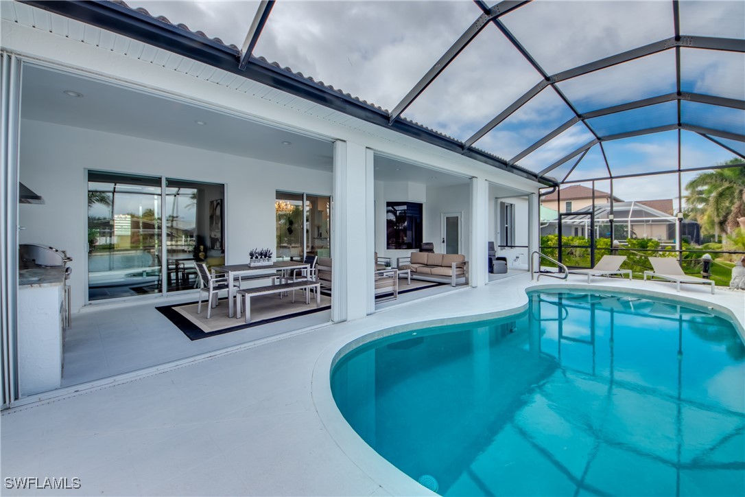 2703 Southwest 43rd Terrace Cape Coral, FL 33914 - Photo 38 of 50 a view of a swimming pool with outdoor seating